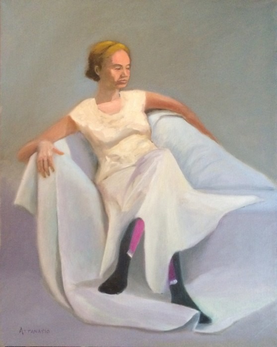 Woman seated on chaise, dressed in white, with colorful stockings